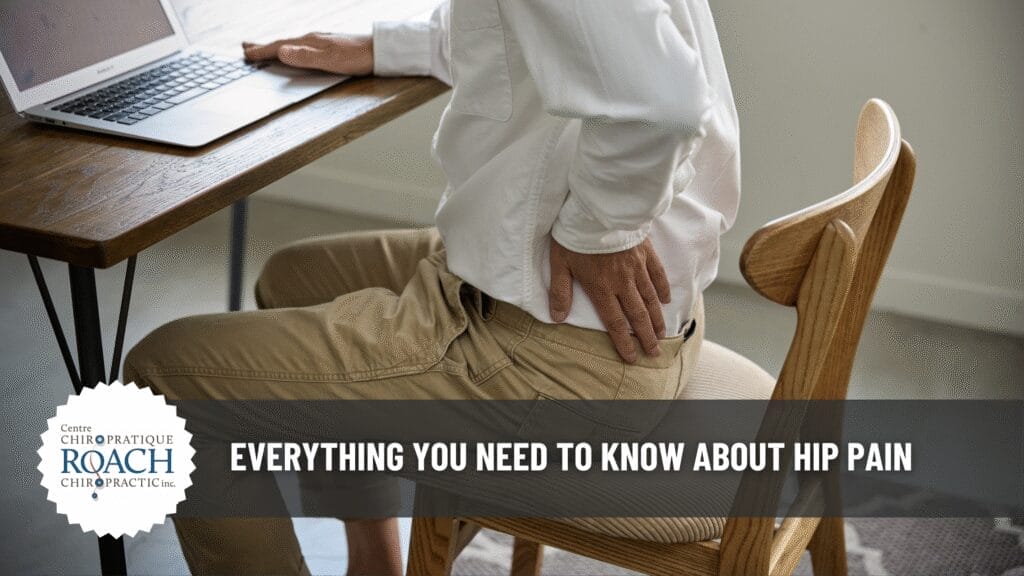 a person sitting at a desk holding their hip in pain.