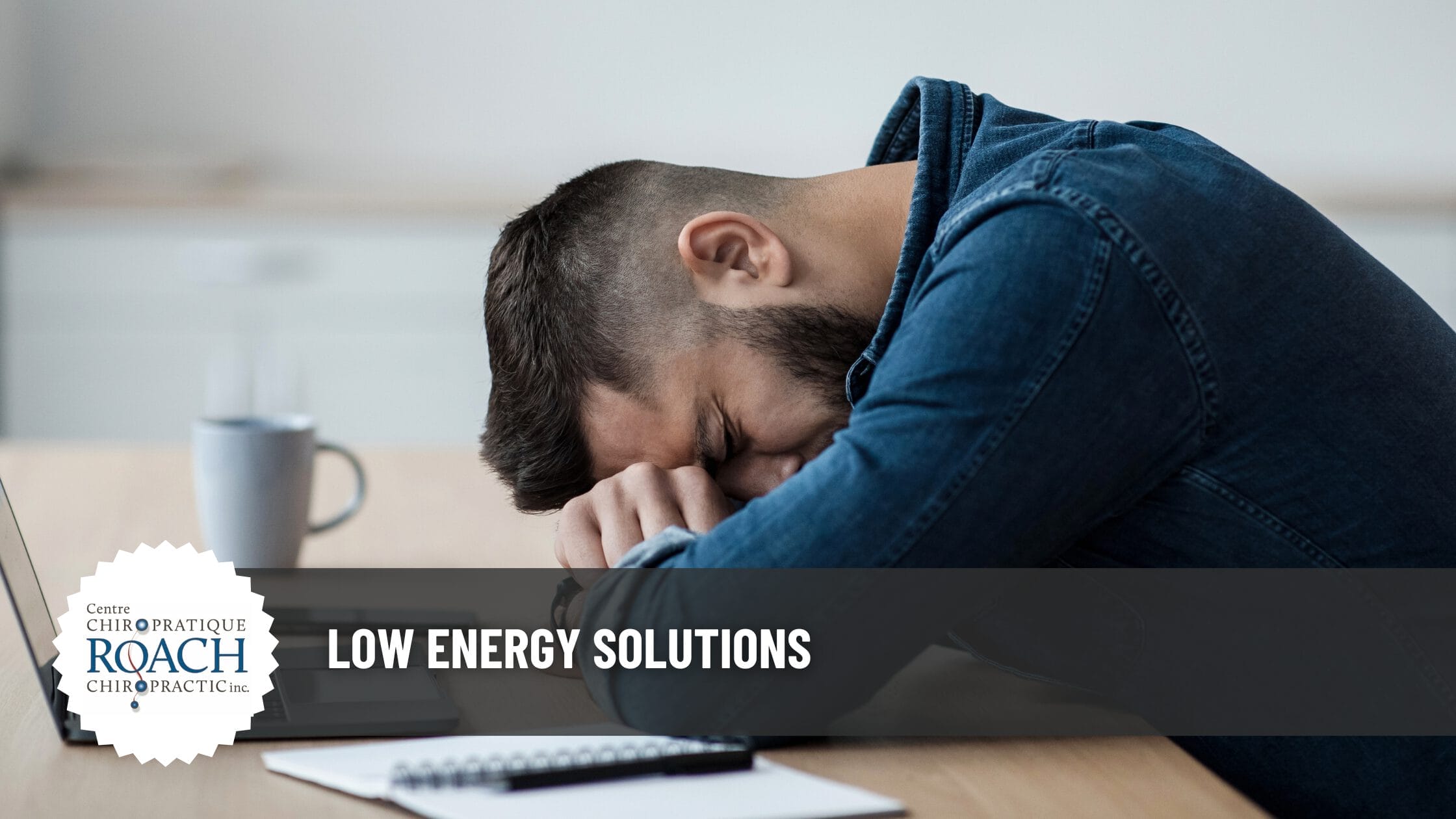 a man sitting in a chair, resting on the desk in front of him due to fatigue