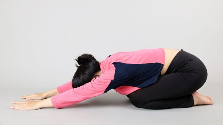 a woman doing the child's pose stretch as a ql pain relief method