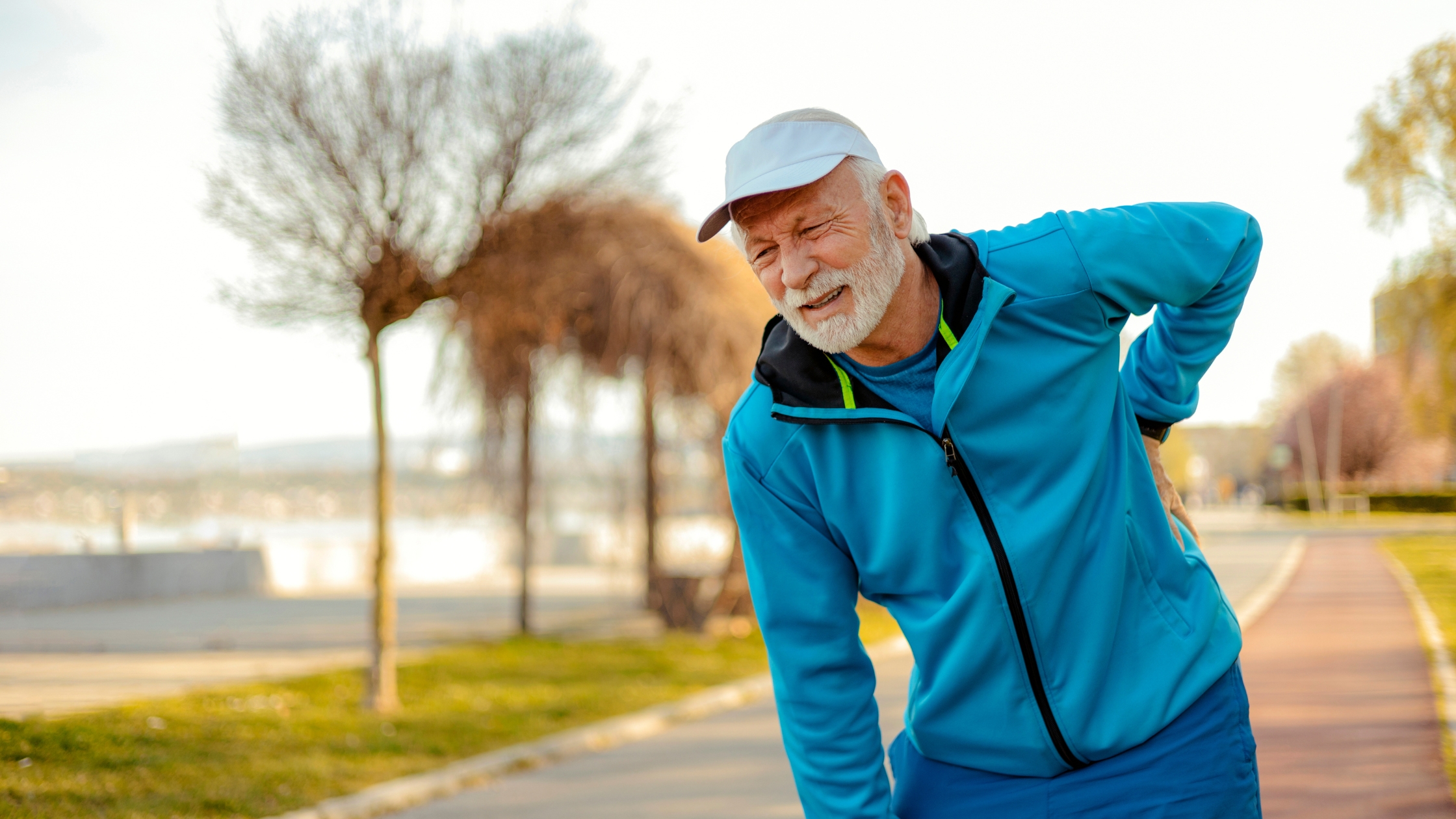 A man suffering from seasonal joint pain holding his back