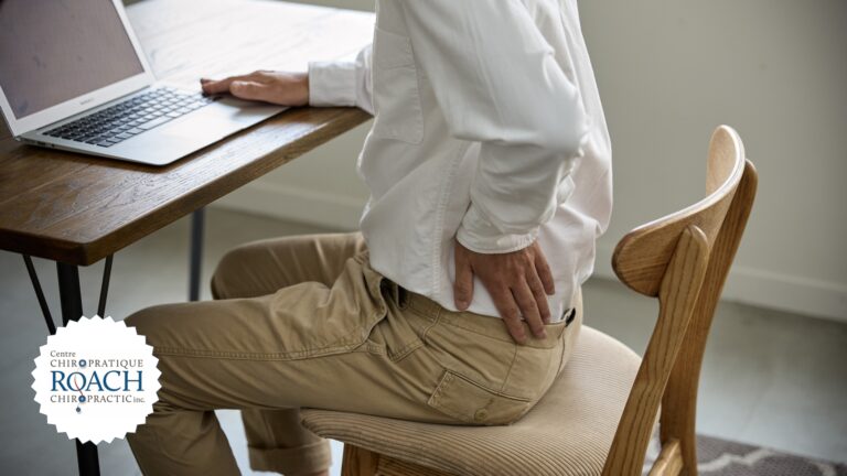 a man sitting at his desk with back pain