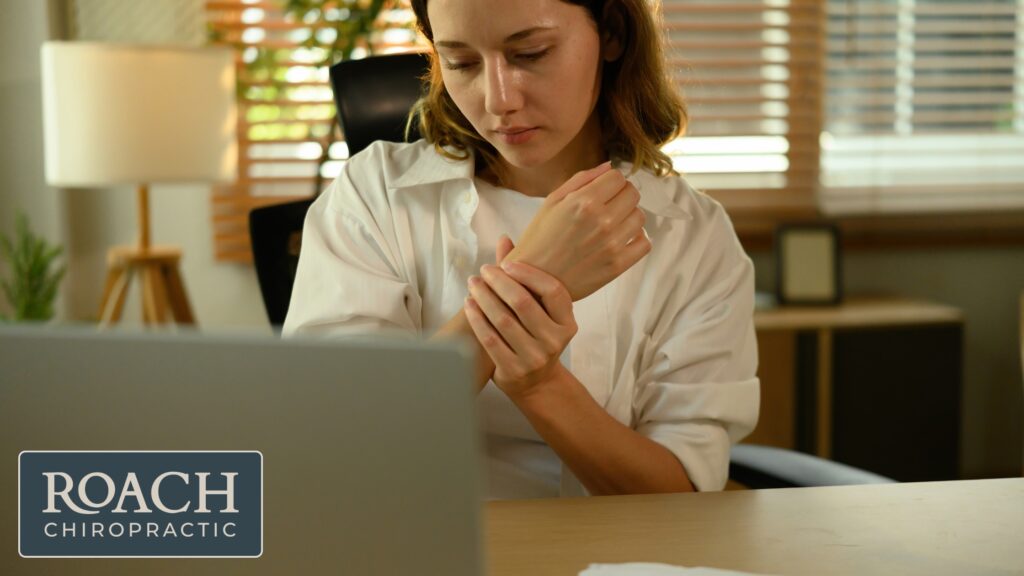 Carpal Tunnel Treatment: How Chiropractic Care Can Help Your Hands Work Better 6 a woman at her desk with wrist pain