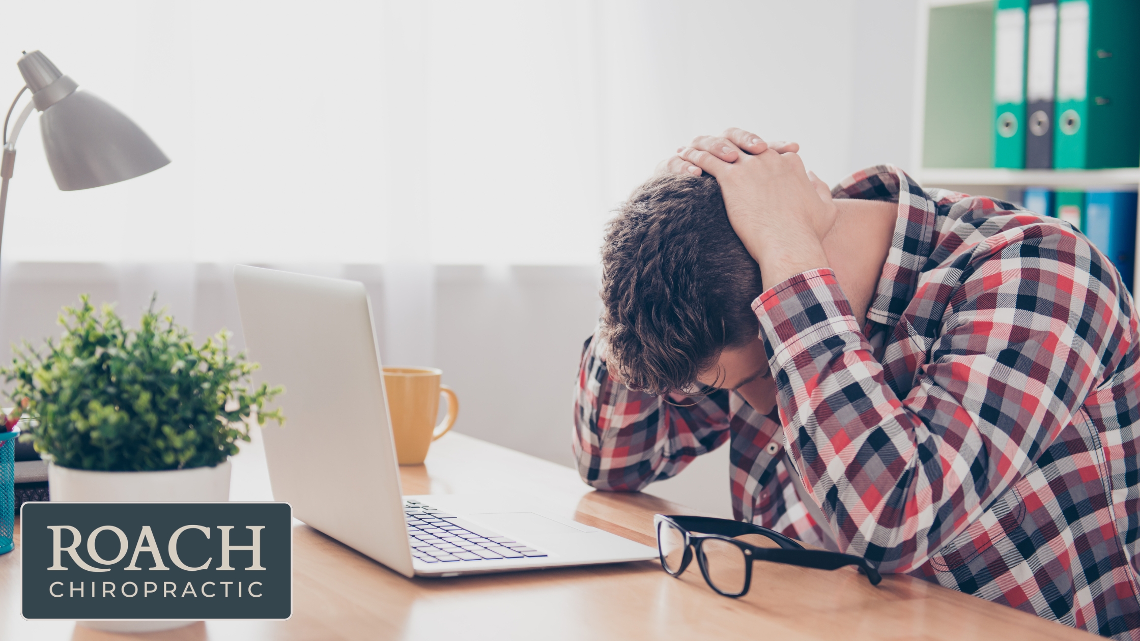 A man at his desk with a headache